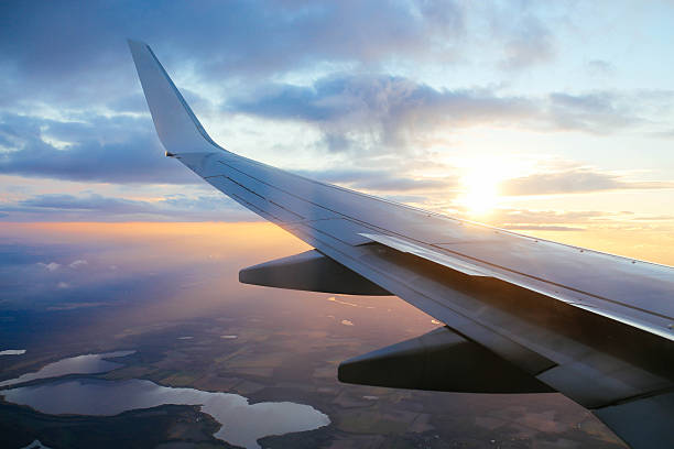 airplane in flight over the europe - wing airplane window sunset imagens e fotografias de stock