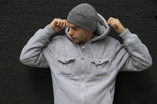 istock Young Man With A  Grey Cap Fixing His Hood 618430500