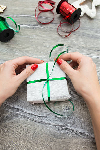 istock Hands of woman decorating Christmas gift box 618430706
