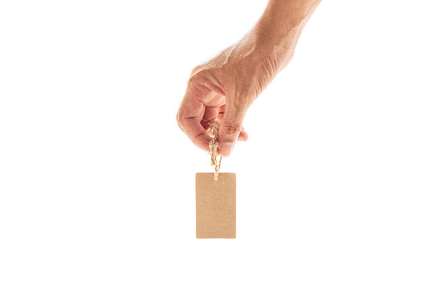 istock hand male  holding small brown tag,price tag, gift tag, 618430886