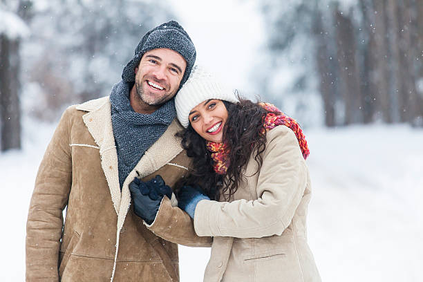istock Young couple resting and embracing in snow forest 618431150