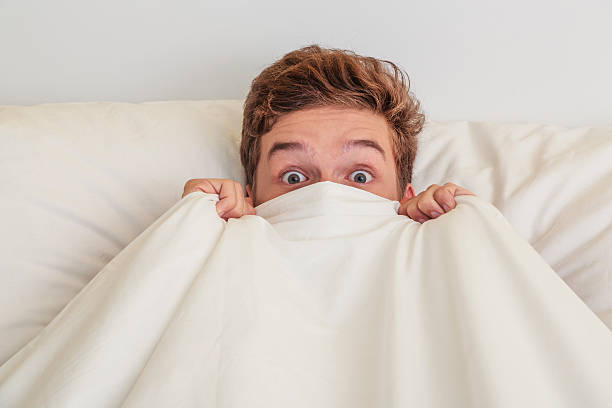 istock Teen boy in white bed 618432524