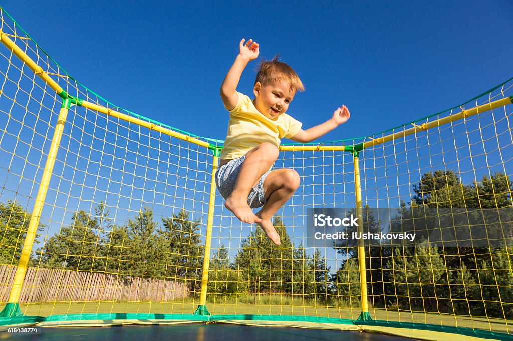 Niño pequeño en un trampolín - Foto de stock de Niño libre de derechos