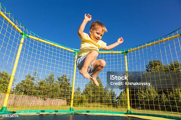 Niño Pequeño En Un Trampolín Foto de stock y más banco de imágenes de Niño - Niño, Trampolín - Artículos deportivos, Niños