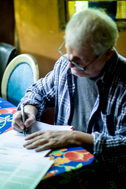 istock Elderly man with glasses signing a text on paper 618440558
