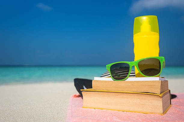 istock Sunscreen, hat and sunglasses on tropical beach 618441698