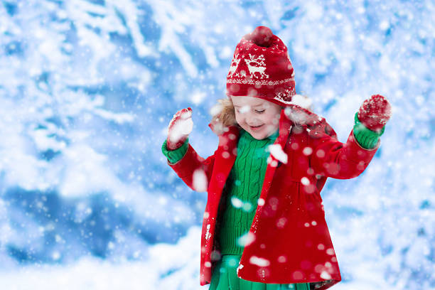 istock Little girl in red jacket playing in snow 618442054