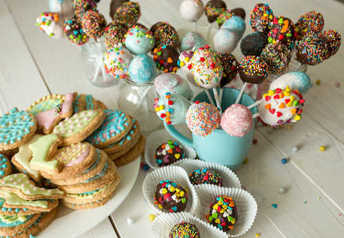 Beautiful decorated cake pops and cookies for Easter on wooden table