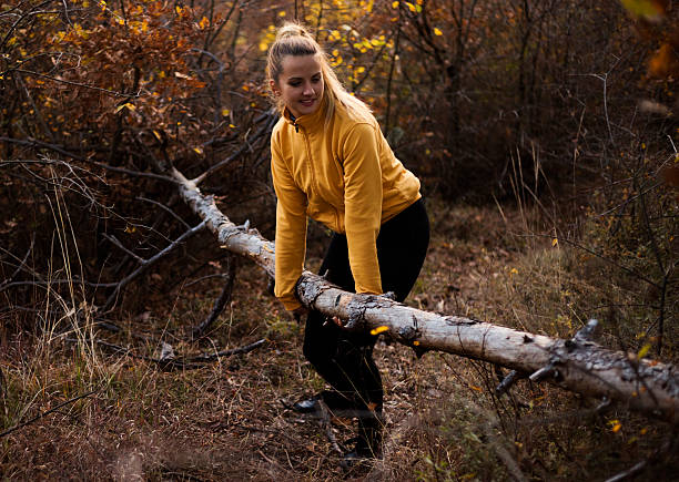 woman in autumn forest is trying to remove fall free. - leafes autumn grass nature imagens e fotografias de stock