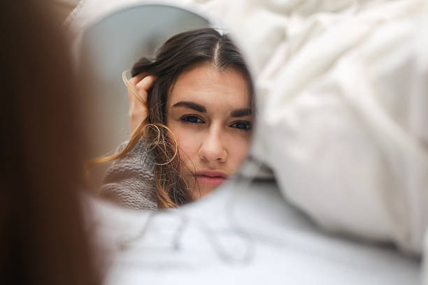 istock young girl looks in the mirror reflection 618444820