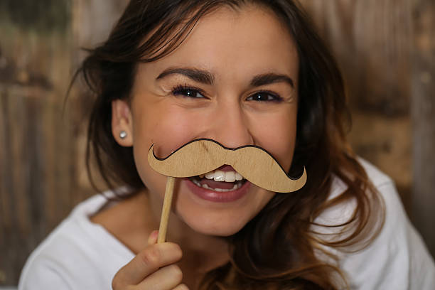 istock young girl with  moustache hipster 618444918