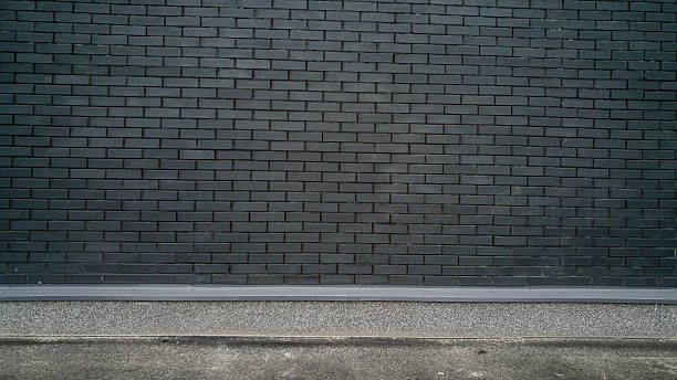istock Background with black brick wall and concrete ground. Place for 618445900