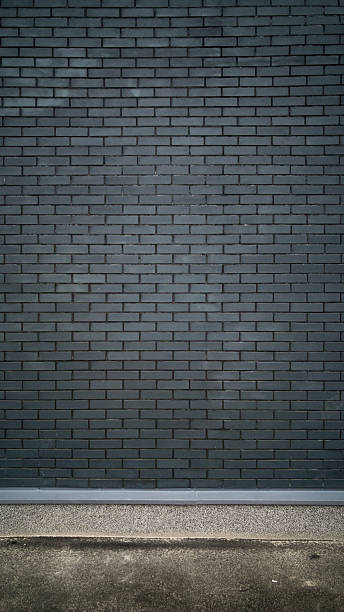 istock Vertical shot of black brick wall and concrete floor 618446216
