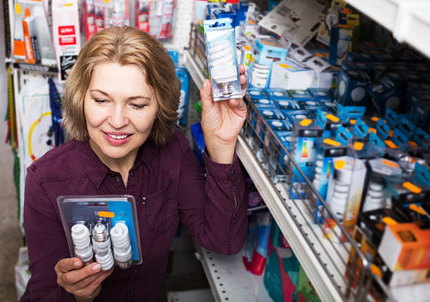istock Woman chooses bulbs in store 618446832
