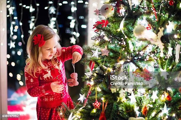 Bambino Che Decora Lalbero Di Natale Nel Soggiorno Di Famiglia Con Camino - Fotografie stock e altre immagini di Albero di natale