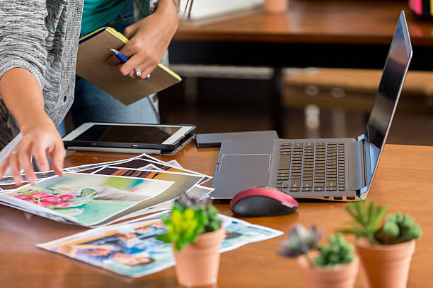 istock Young woman selects photos in creative design firm 618447448