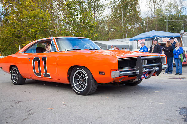 The General Lee on Main Street Beattyville, KY, USA - October 22, 2016: A crowd watches as a replica of the famed General Lee makes a Main Street appearance at the annual Woolly Worm Festival parade in Beattyville, Kentucky.  The iconic car, a 1969 Dodge Charger, was featured on the hit 1980s CBS television program "The Dukes of Hazzard". the general lee stock pictures, royalty-free photos & images
