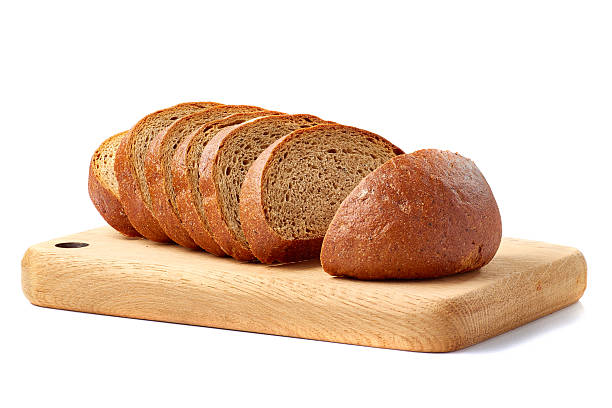 istock Loaf of bread sliced on wooden board ower white 618451462