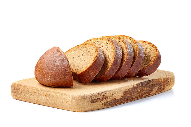 istock Loaf of bread sliced on wooden board ower white 618451546