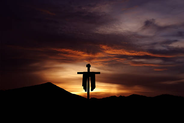 istock Christian cross over dark sunset background 618453202