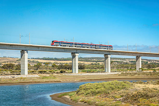 vista laterale del treno della metropolitana di adelaide che attraversa l'imponente ponte ferroviario sul fiume onkaparinga - train australia electric train image foto e immagini stock