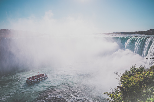 DSLR picture of the famous Niagara Falls on a nice day of October. There is a tourists boat going to the waterfalls.