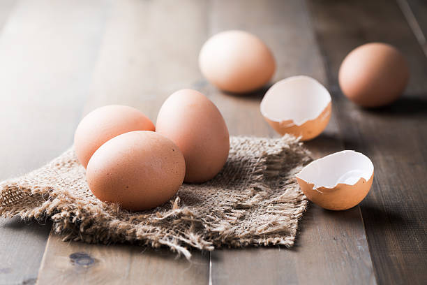 surowe świeże jajko na tle drewna - agriculture brown burlap cholesterol zdjęcia i obrazy z banku zdjęć