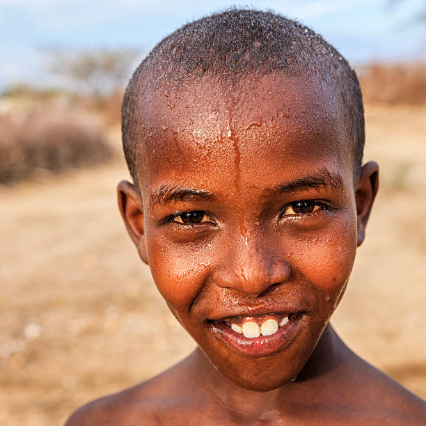 Portrait of happy African young boy on savanna, East Africa Portrait of happy African young boy from Samburu tribe, on savanna. Samburu tribe is one of the biggest tribes of north-central Kenya, and they are related to the Maasai. kenyan man stock pictures, royalty-free photos & images
