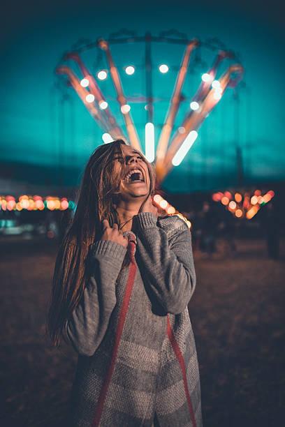 młoda kobieta bawiąc się w parku rozrywki targi w nocy - ferris wheel luna park amusement park carnival zdjęcia i obrazy z banku zdjęć