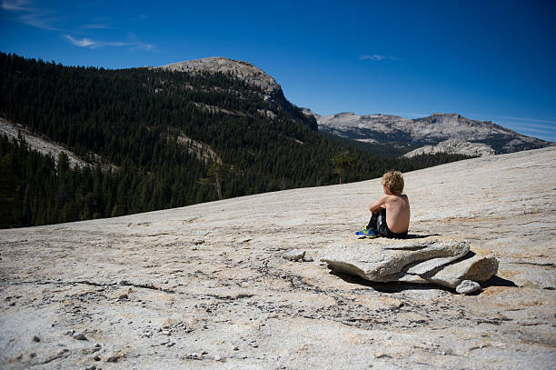 Child sitting quietly looking at the view in the Yosemite backcountry. 
