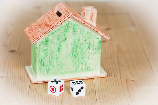 istock Two dice and house bank on wooden table 618466790