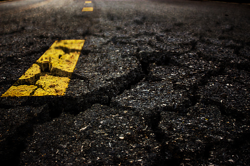 Crack textured asphalt road background.