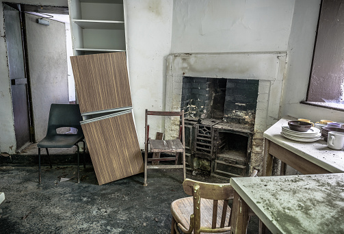 An old, abandoned kitchen with old cast iron fireplace.