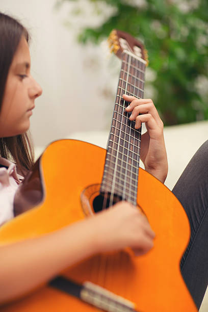 istock Cute little girl practicing her guitar lessons at home 618515246
