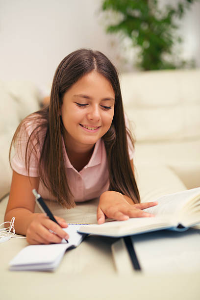 istock Girl writing in a notebook lying on the bed 618517108