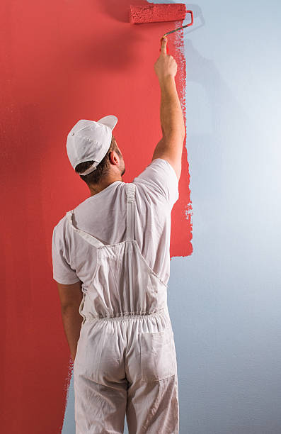homme mur peinture avec rouleau - painting wall paint paint roller photos et images de collection