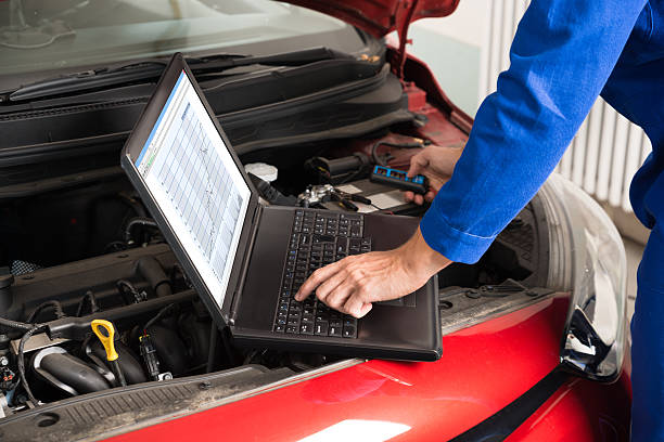 istock Mechanic Examining Car Engine With Help Of Laptop 618519134