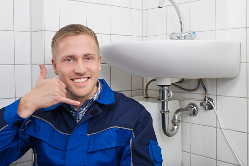 Portrait Of A Happy Male Plumber Making Call Me Gesture