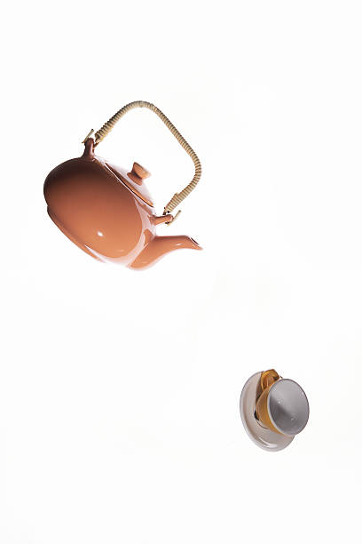 Flying orange teapot on white background. Studio photography. Object shooting.
