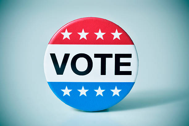 closeup of a badge with the word vote written in it, for the United States election, with a slight vignette added