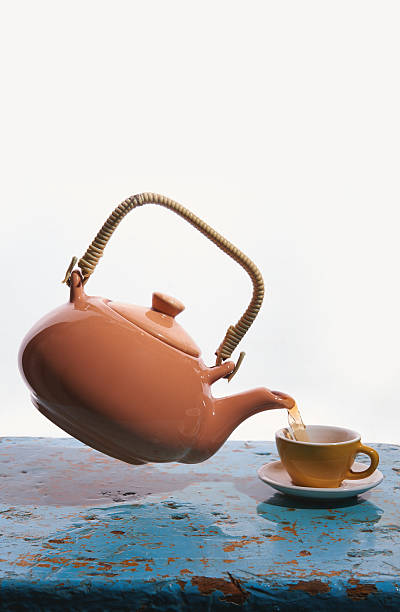 istock Flying teapot, tea cup. To pour tea. Drops. White background. 618521738
