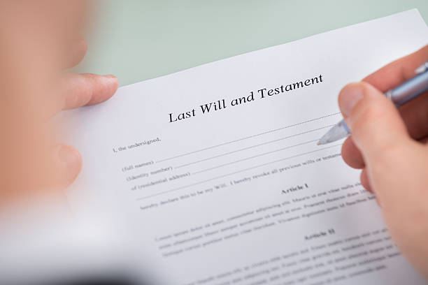 istock Person Hand Over Last Will And Testament Form 618521896
