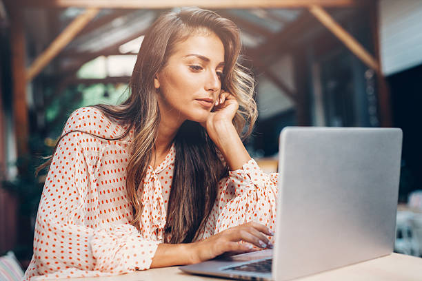 istock Young woman using a laptop at the cafe 618523718