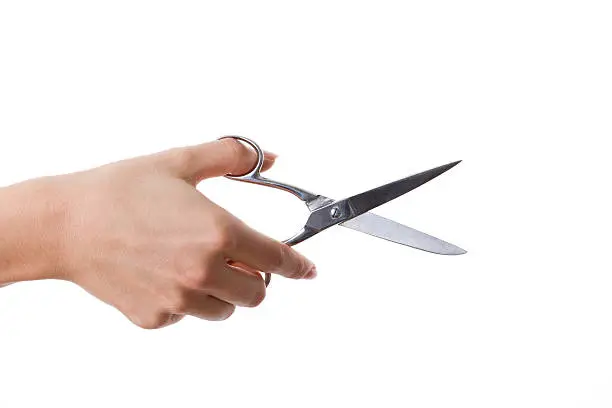 Woman hand holding scissors on white background