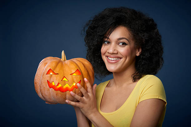 Smiling woman holding Halloween pumpkin