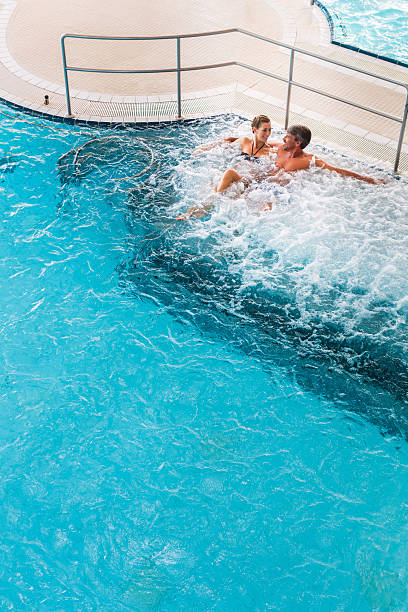 istock Couple in thermal wellness spa on water massage 618527678