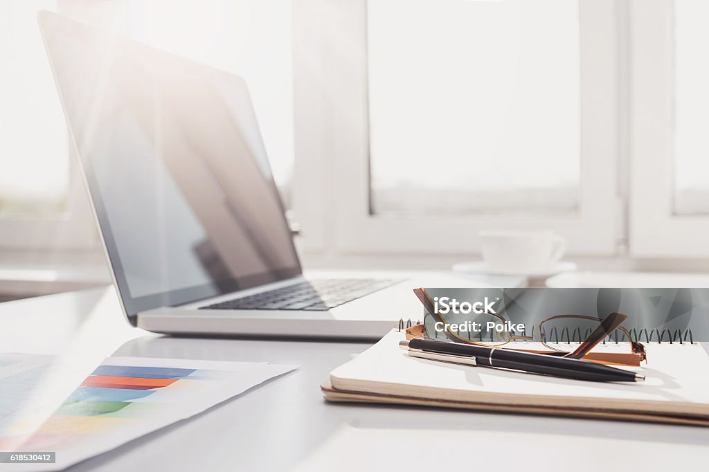 Place of work Table with laptop, notebook and coffee cup Desk Stock Photo