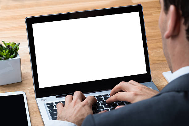 istock Businessman Using Laptop With Blank Screen At Desk 618530622