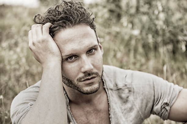 istock Good looking male model sitting on grass 618530938