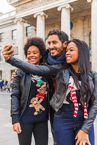 istock Friends Taking Selfie While Christmas Shopping in Ugly Festive Sweaters 618531240